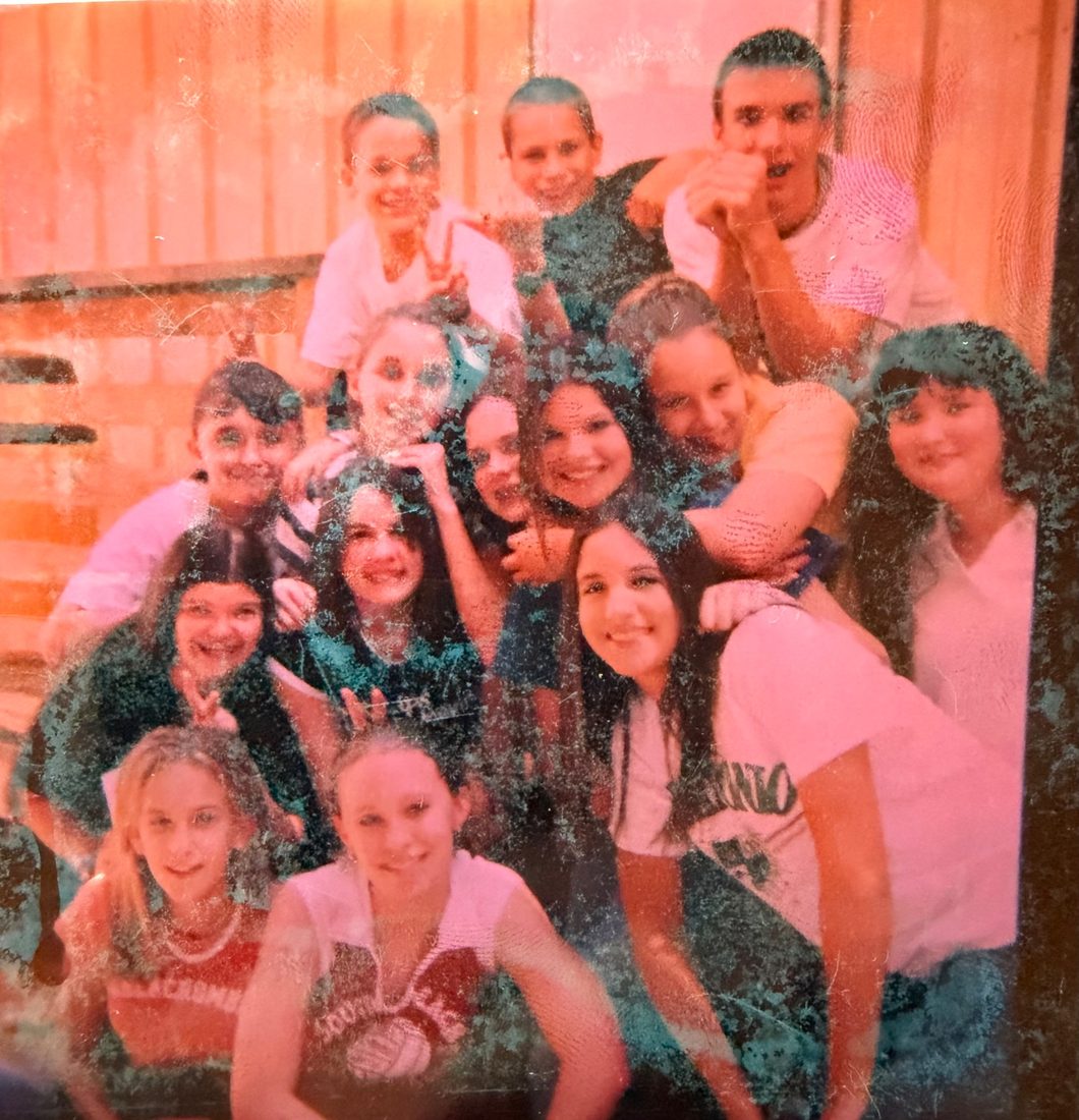 A big group of Class of '08 friends piled together for a photo in middle school